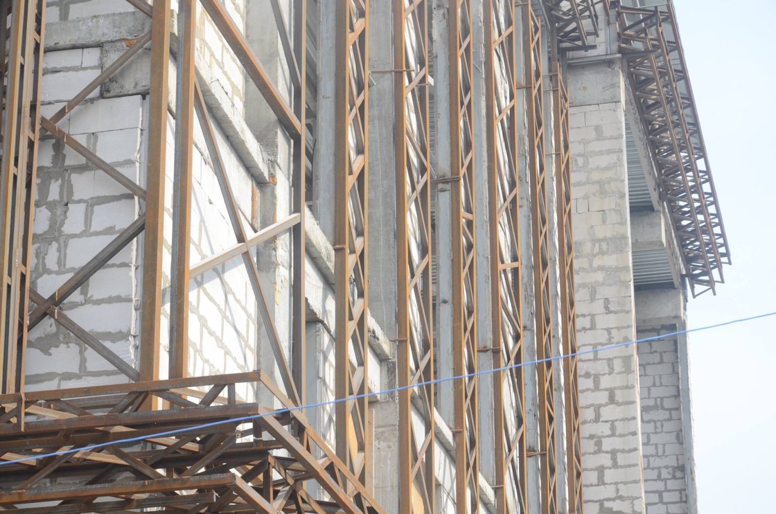 The restaurant in Almaty under construction: steel roof trusses over the brick shell.