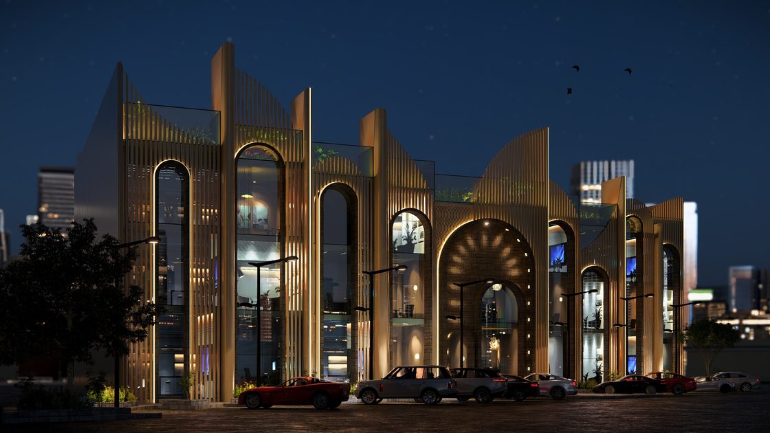 Night view of the arcade, the pointed-arch fins lit from the glazed interior behind.