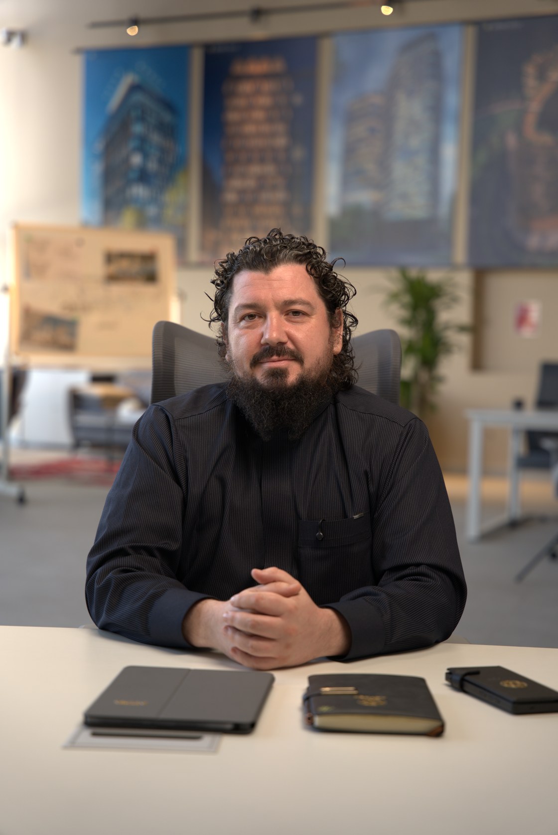 Rustam Khaitmetov at his desk, project boards behind him